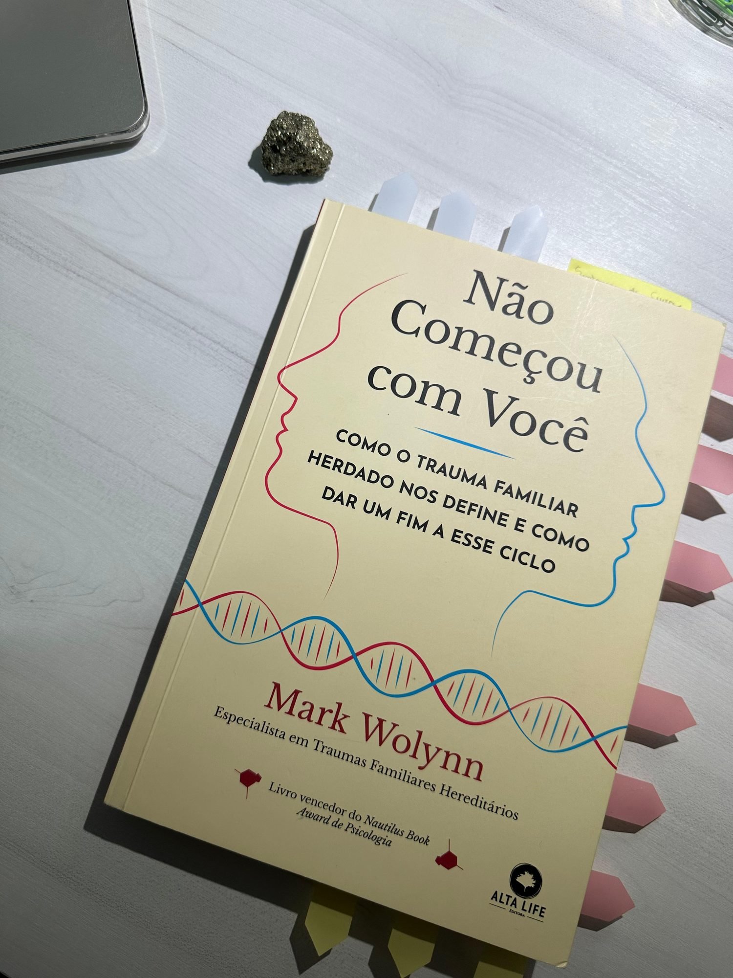 O livro Não Começou com Você sobre a mesa, ao lado de um cristal
